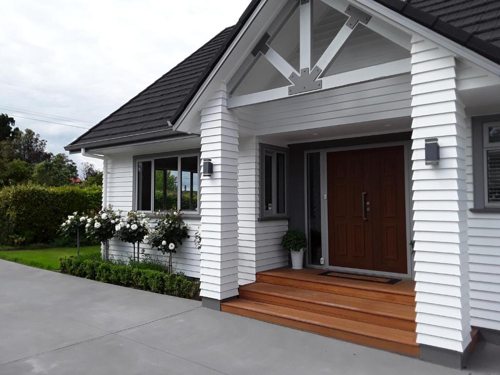 a house with a wooden porch with a door at No. 6 Heathcote in Taupo