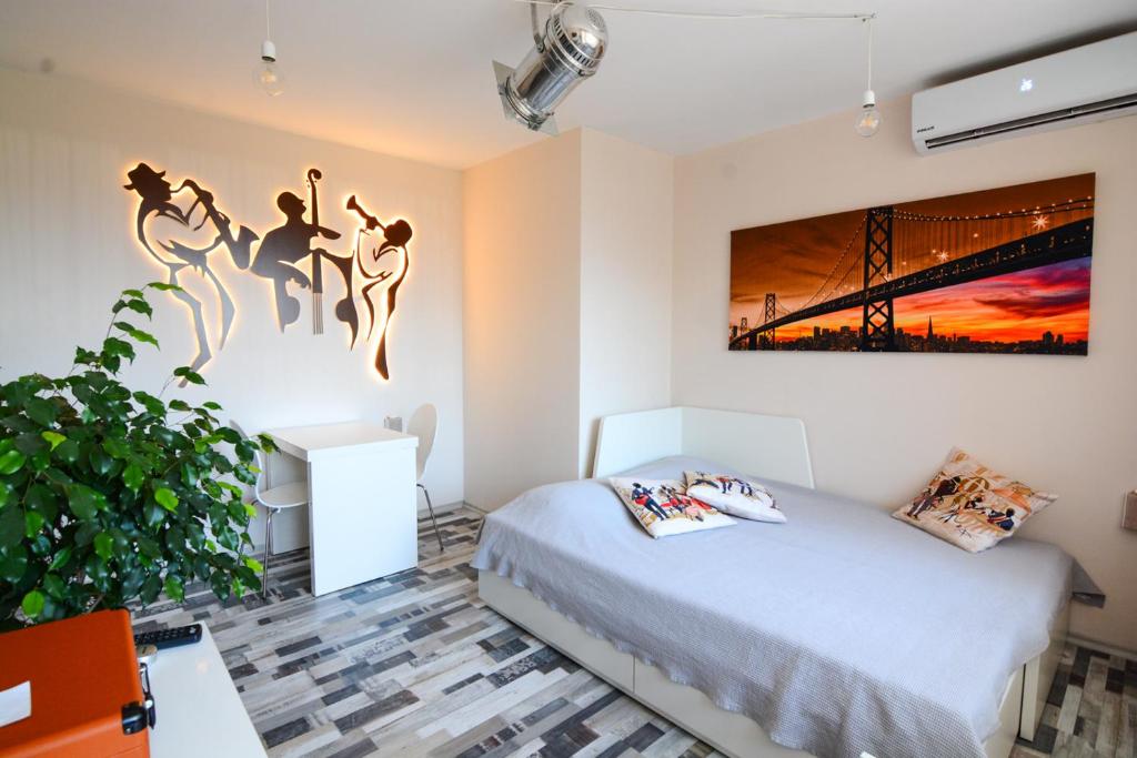 
a bedroom with a bed and a painting on the wall at Jazzy Sofia Downtown Apartment in Sofia
