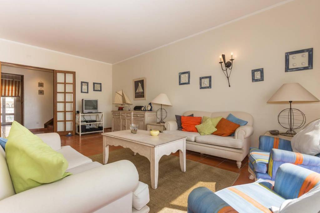 a living room with two couches and a table at Marina de Vilamoura Apart in Vilamoura