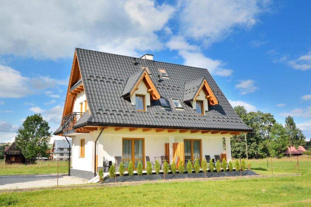 una pequeña casa blanca con techo negro en Toporowe Domki w Chochołowskiej, en Witów