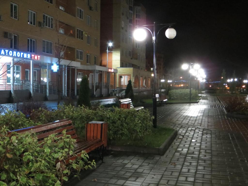 une rue de la ville la nuit avec des bancs et des lumières dans l'établissement Apart-Hotel on Solnechniy 10, à Joukovski