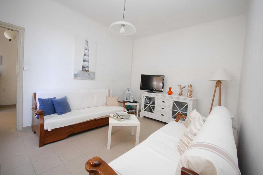 a living room with a white couch and a tv at Lovati Beach in Forte dei Marmi