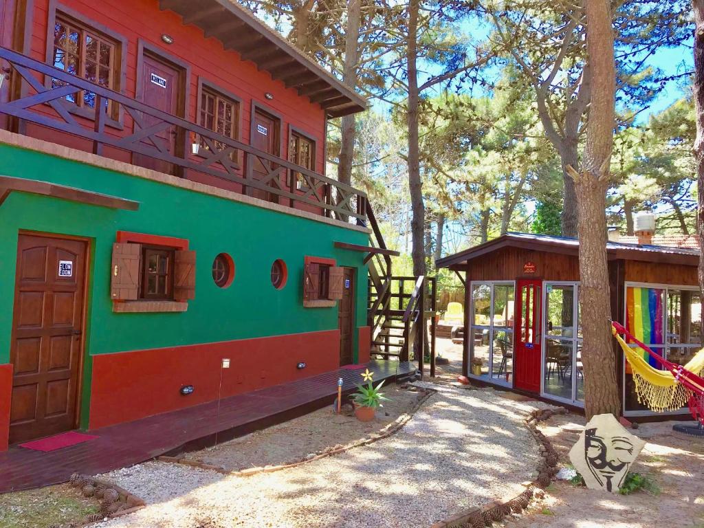 un edificio verde con parque infantil junto a un árbol en B&B Mi Casa Es Tu Casa, en Mar Azul