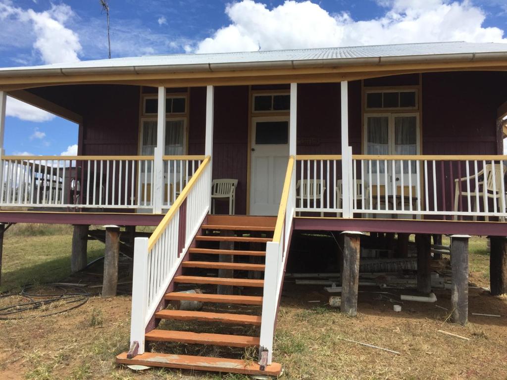 a purple house with a porch and stairs at Rangemore Estate in Maclagan