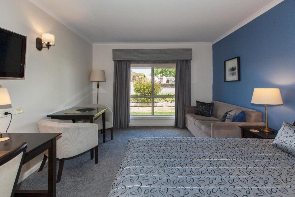 a hotel room with a bed and a couch at Ararat Motor Inn in Ararat