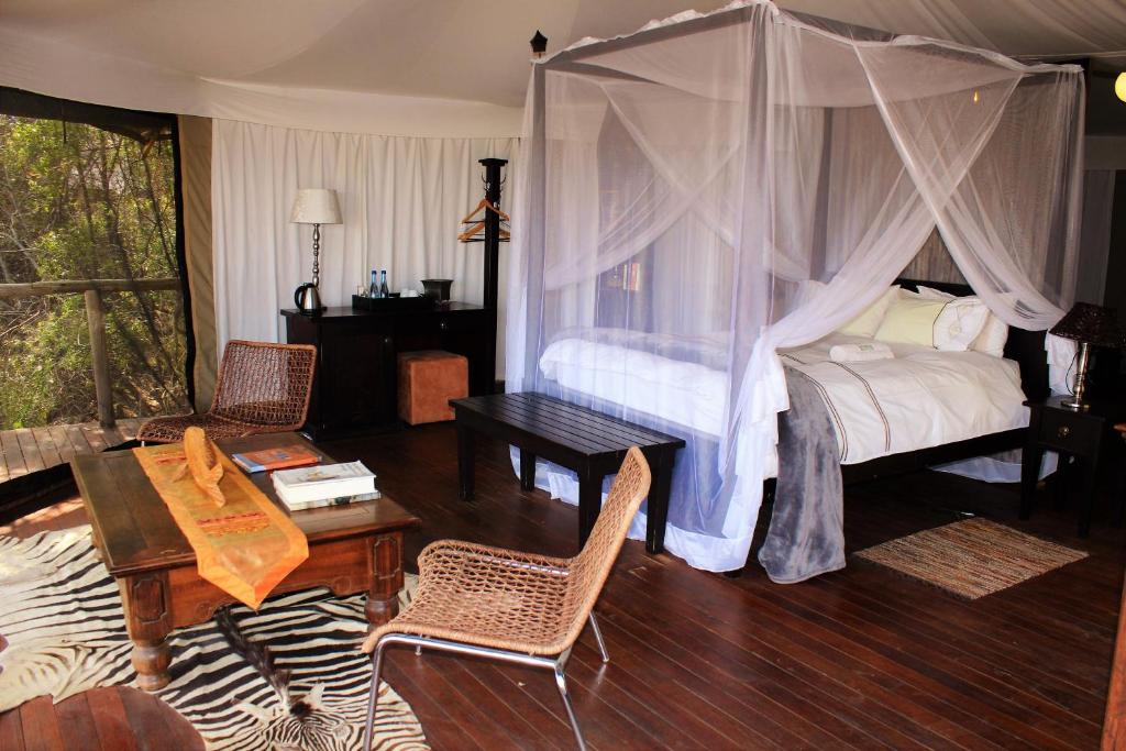 ein Schlafzimmer mit einem Himmelbett in der Unterkunft Taranga Safari Lodge in Rundu