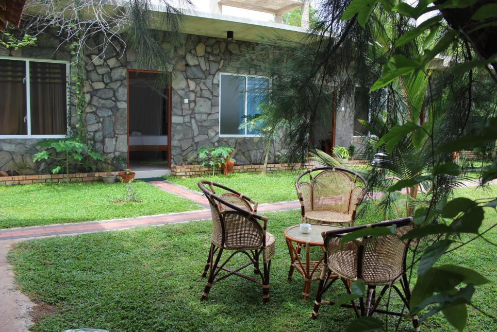 three chairs and a table in front of a house at Airport Green Hotel in Katunayake
