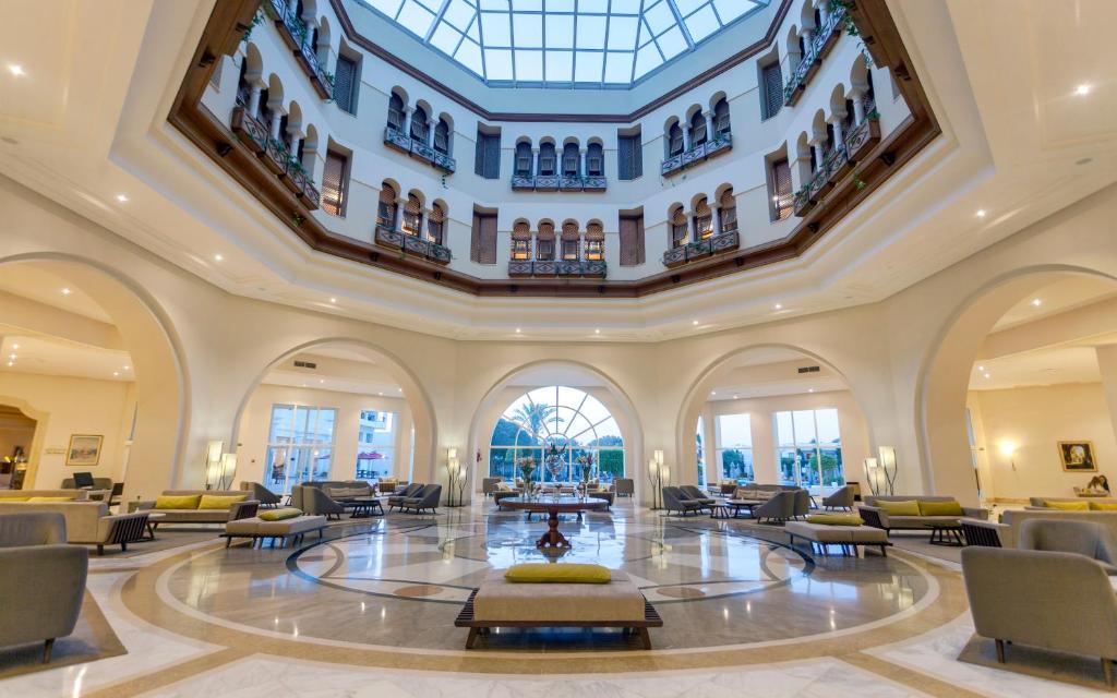 a large lobby with a large ceiling with windows at El Mouradi Gammarth in Gammarth
