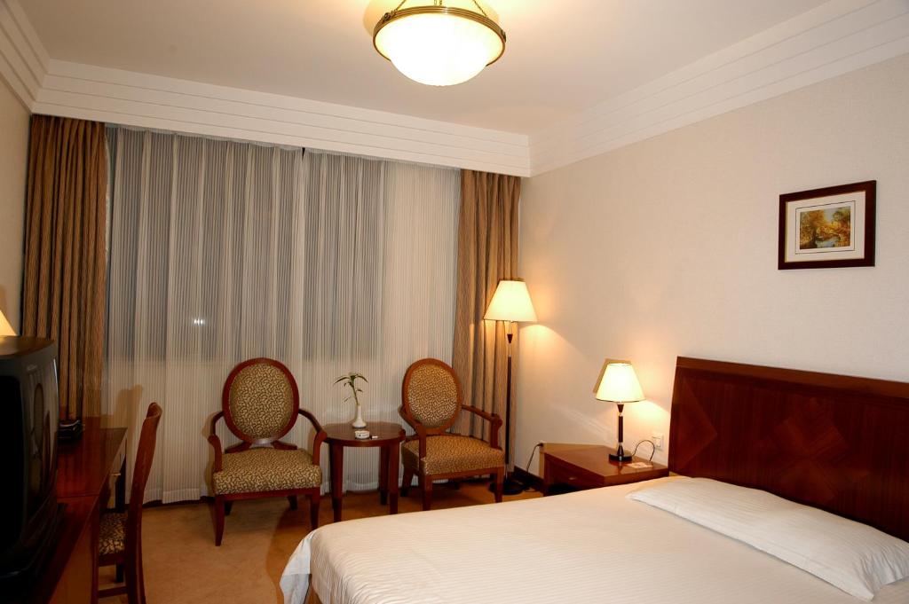 Postel nebo postele na pokoji v ubytování Jin Jiang Pacific Hotel