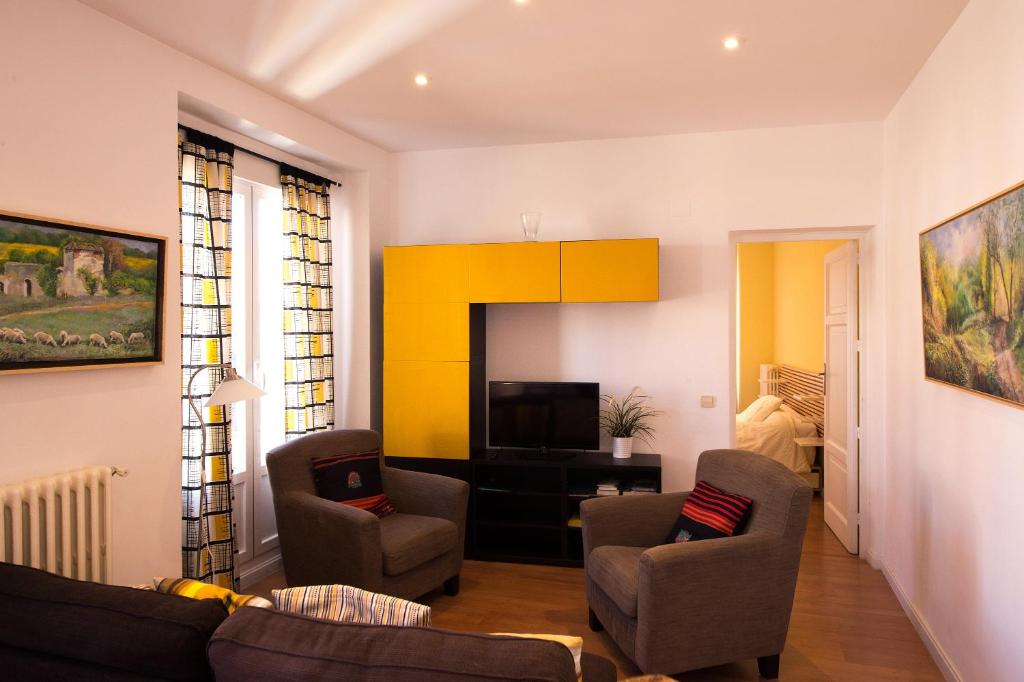 - un salon avec deux chaises et une télévision dans l'établissement For You Rentals Chueca Apartment SON1, à Madrid