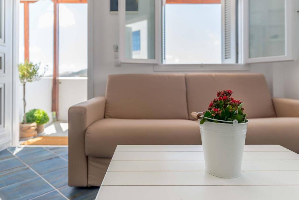 a living room with a couch and a potted plant at Michalakis Seaside Suites in Pollonia