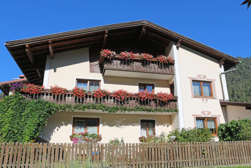 ein Gebäude mit Blumenkästen und einem Zaun in der Unterkunft Pension Delacher in Ried im Oberinntal