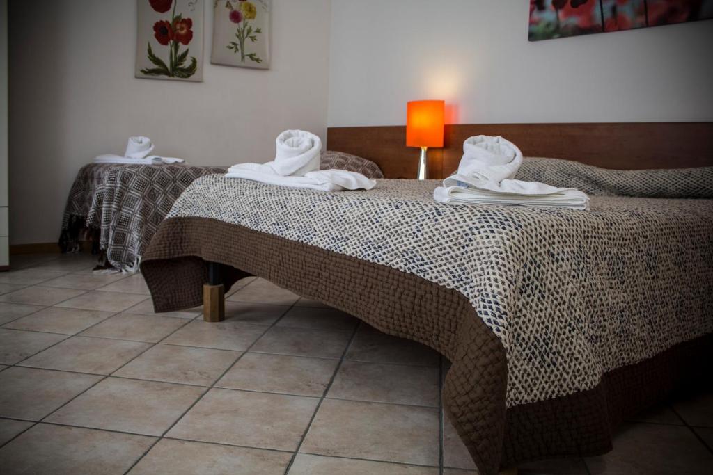 een slaapkamer met 2 bedden en handdoeken bij Albergo Diffuso Zoncolan in Ovaro