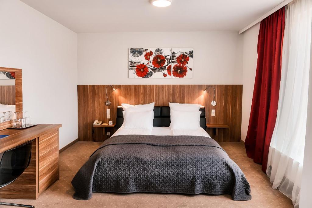 a bedroom with a bed and a dresser at Hotel President in Timişoara