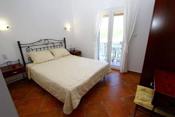 a bedroom with a bed and a large window at Villa Polyxeni in Sivota