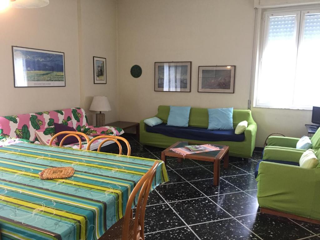 sala de estar con sillas verdes y azules y sofá en Appartamento Roggero, en Levanto