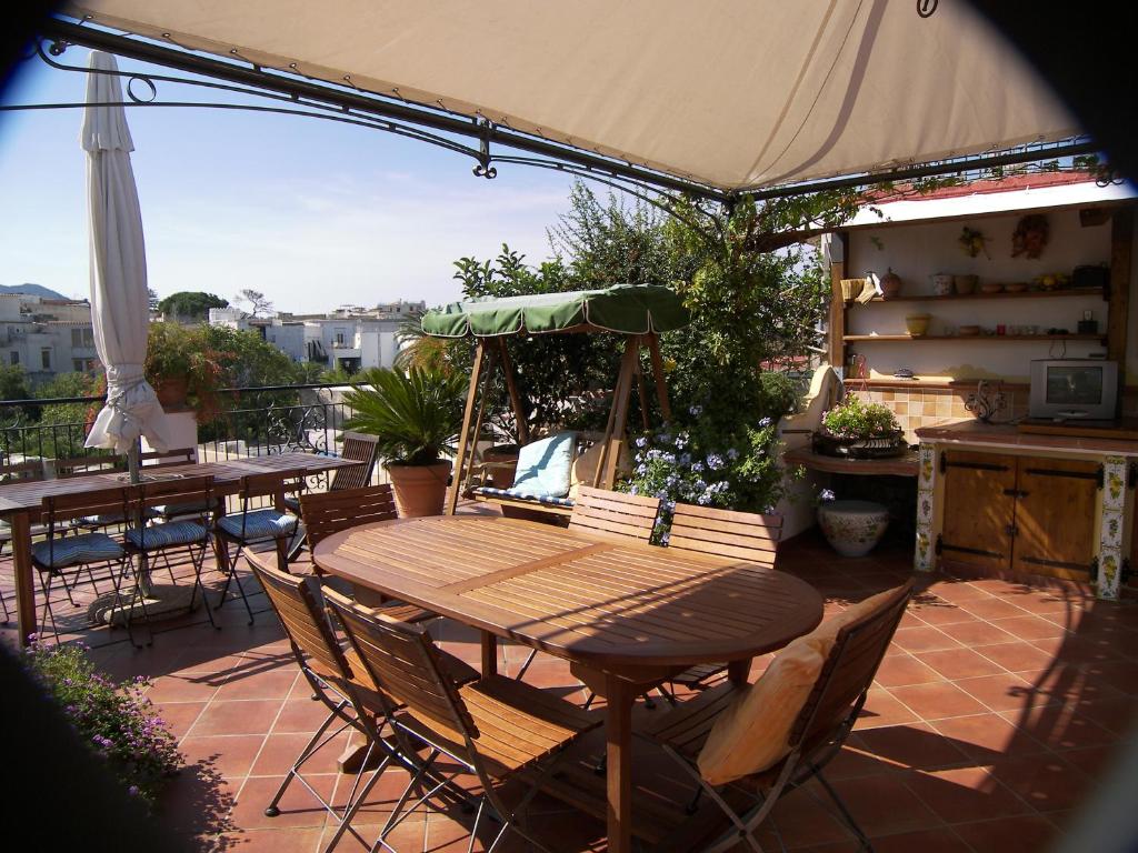 d'une terrasse avec des tables, des chaises et un parasol. dans l'établissement Hotel Villa Verde, à Ischia