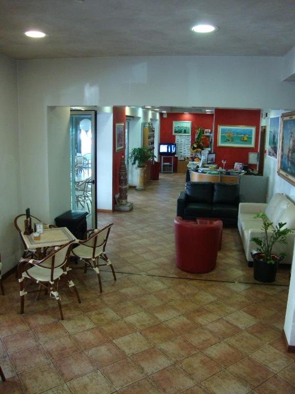 a lobby with a couch and a table and chairs at Hotel Venezia in Caorle