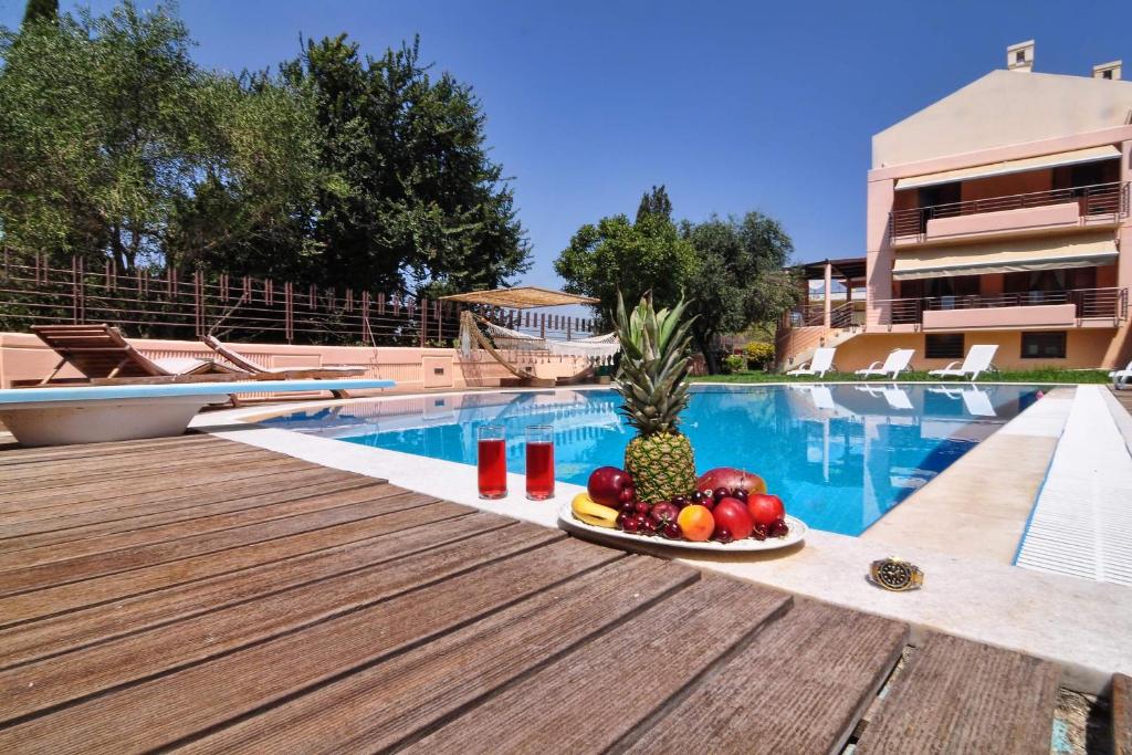 un plato de fruta sentado en una mesa junto a una piscina en Villa Figareto en Corfú