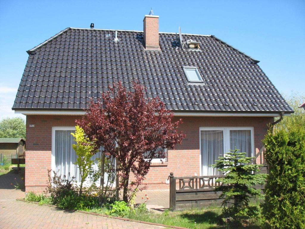 a red brick house with a black roof at Peaceful Holiday Home in Dranske on an Island in Hof Dranske