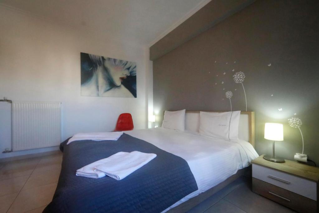 アテネにあるMetaxourghio Boutique Apartmentのベッドルーム1室(ベッド1台、タオル2枚付)