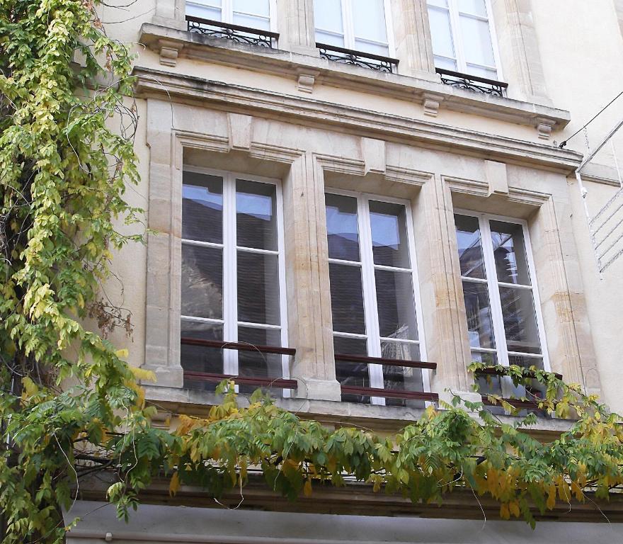 a building with windows and potted plants on it at Tourny - Studio cosy Centre médiéval Sarlat in Sarlat-la-Canéda