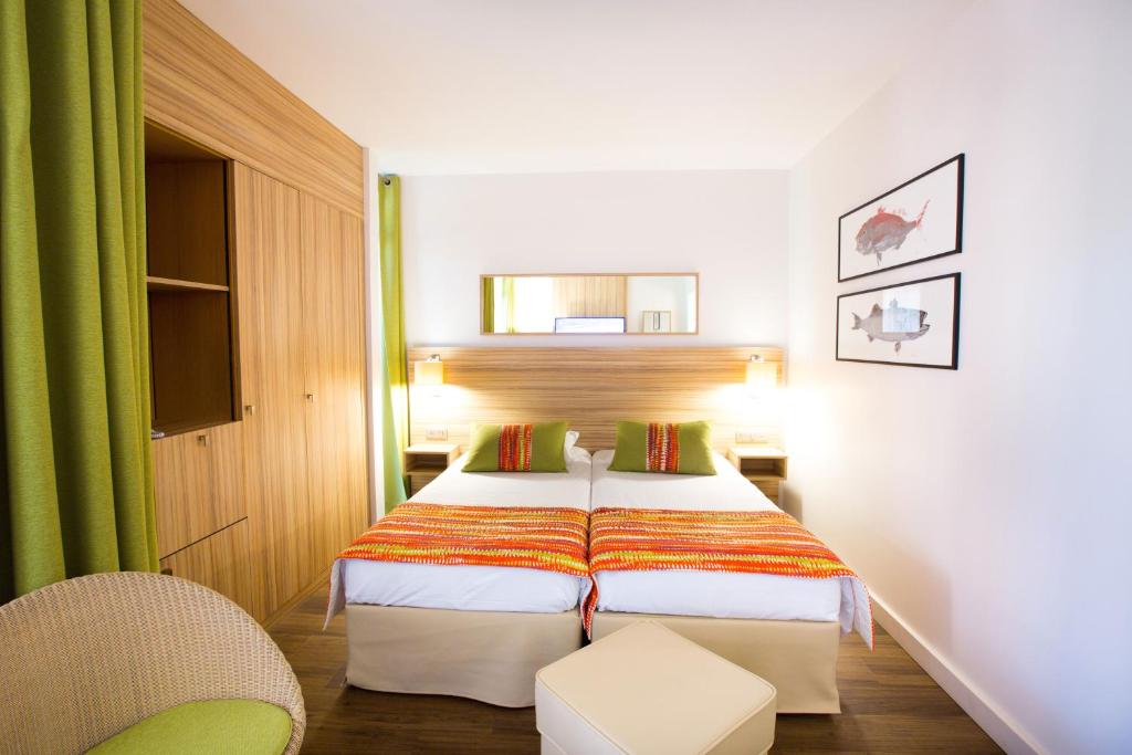 a hotel room with a bed and a chair at Hôtel Vacances Bleues Delcloy in Saint-Jean-Cap-Ferrat