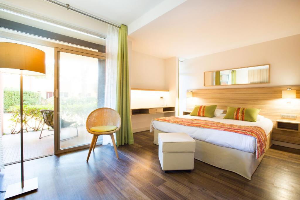 a hotel room with a bed and a large window at Hôtel Vacances Bleues Delcloy in Saint-Jean-Cap-Ferrat