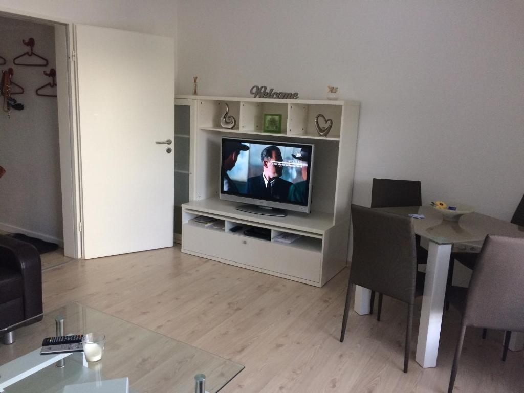 ein Wohnzimmer mit einem TV und einem Esstisch in der Unterkunft FeWo direkt am Lift in Winterberg