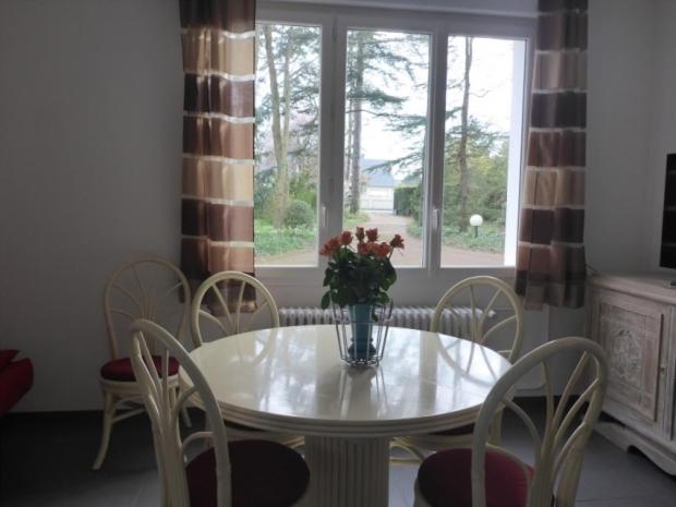 einen weißen Tisch mit Stühlen und eine Vase mit Blumen darauf in der Unterkunft Le Buisson in Montlouis-sur-Loire