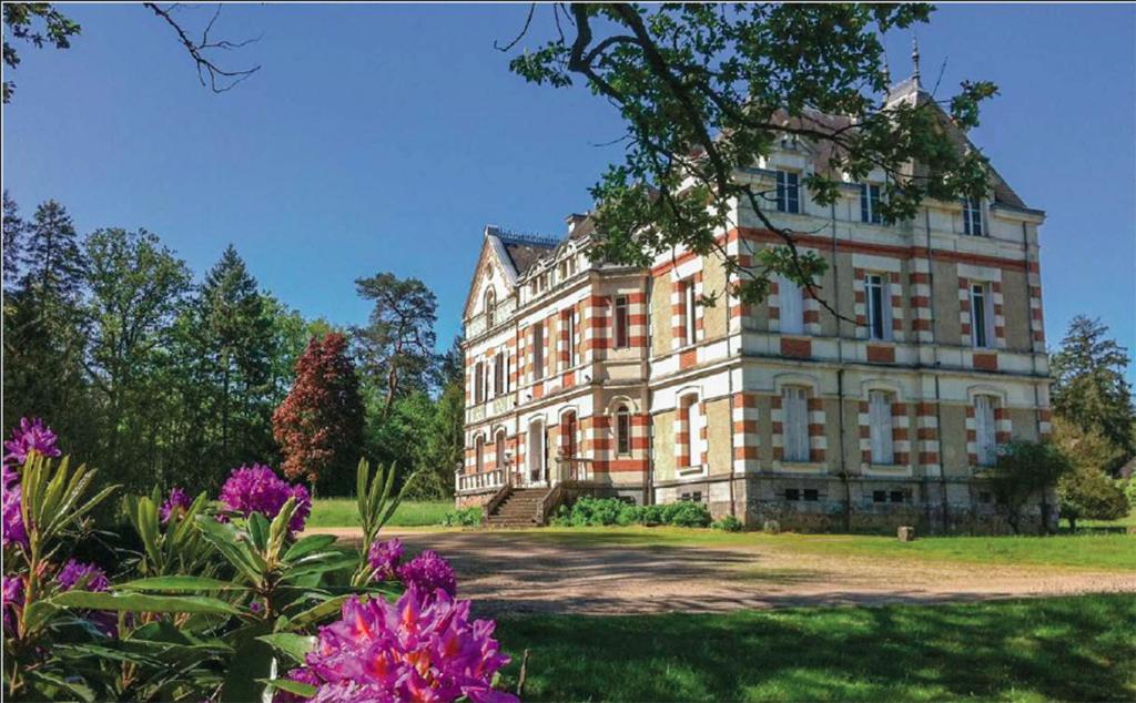 a large building with flowers in front of it at Domaine de la Haute-Porte in Souvigné-sur-Sarthe