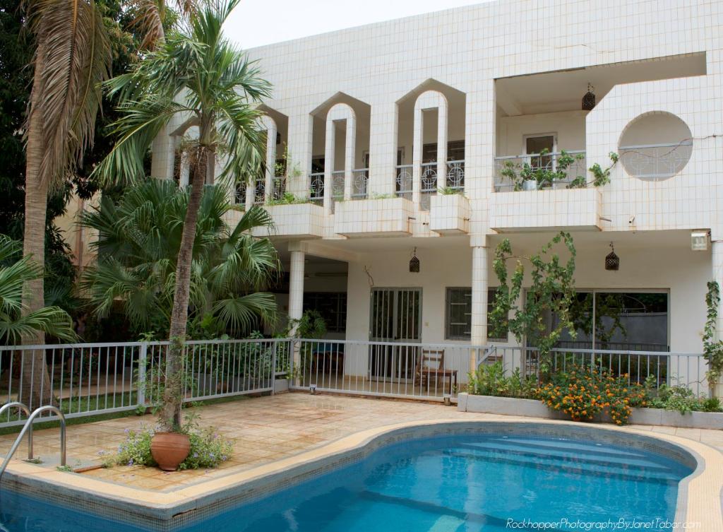a house with a swimming pool in front of it at B & B Le Nomade in Ouagadougou