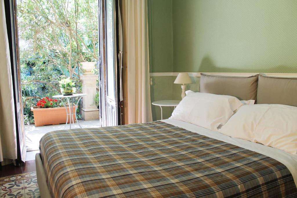 a bedroom with a bed and a large window at Inn The Garden in Catania