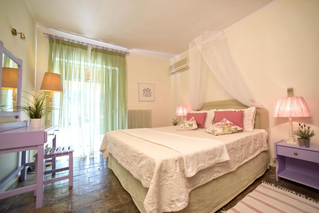 - une chambre avec un lit et des oreillers roses dans l'établissement Isabella Country House, à Gouviá