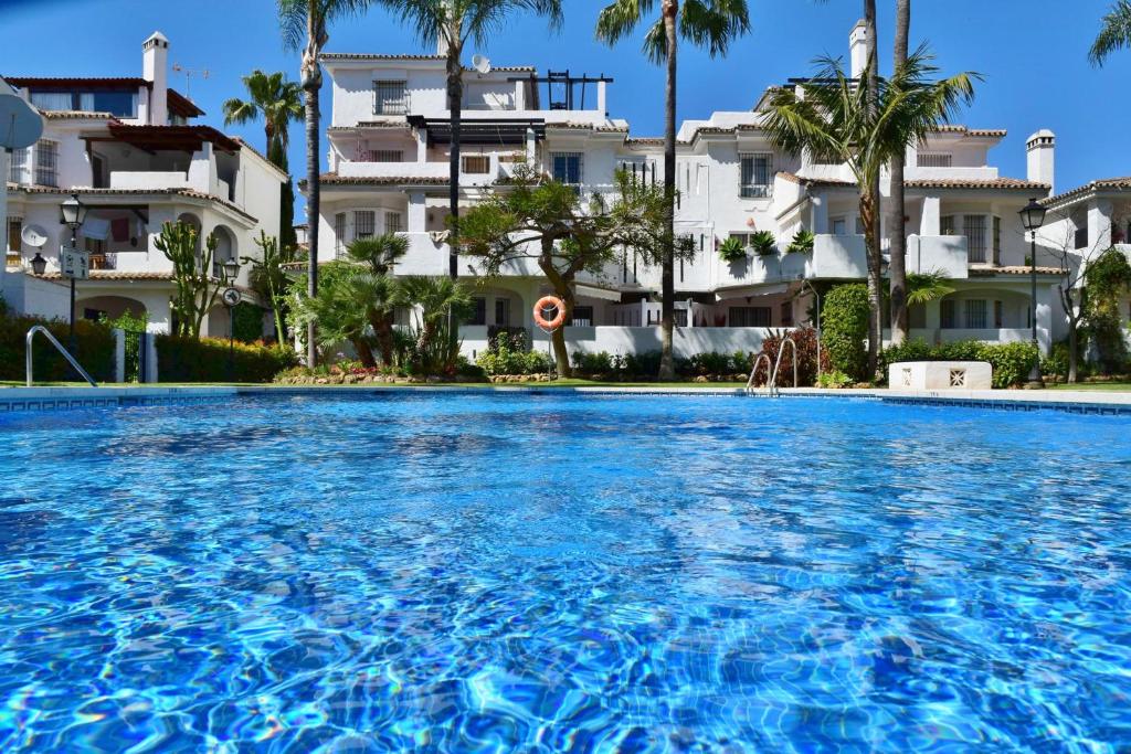 une piscine en face d'un bâtiment dans l'établissement SERINAMAR- Los Naranjos de Marbella, à Marbella