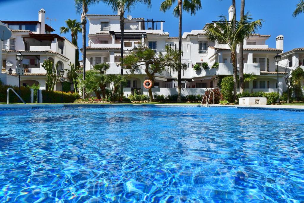 a swimming pool in front of a building at Apartamentos y casas SERINAMAR- Banús, Marbella in Marbella