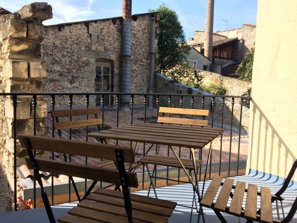 een houten tafel en banken op een balkon bij Une Terrasse aux Chartrons in Bordeaux