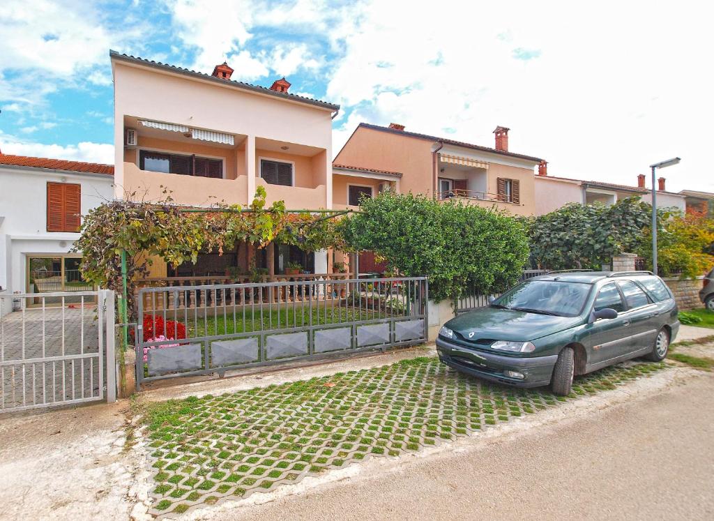 une voiture garée devant une maison dans l'établissement Apartments Sergio 1499, à Fažana