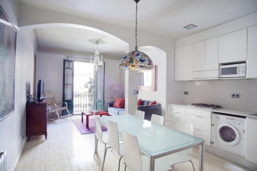 een keuken en eetkamer met een tafel en stoelen bij ApartEasy - Authentic Family Apartment in Barcelona