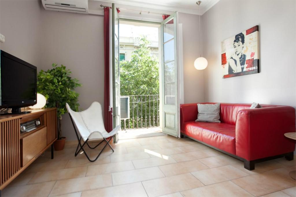 バルセロナにあるApartEasy - Family Sant Antoni apt.のリビングルーム(赤いソファ、テレビ付)