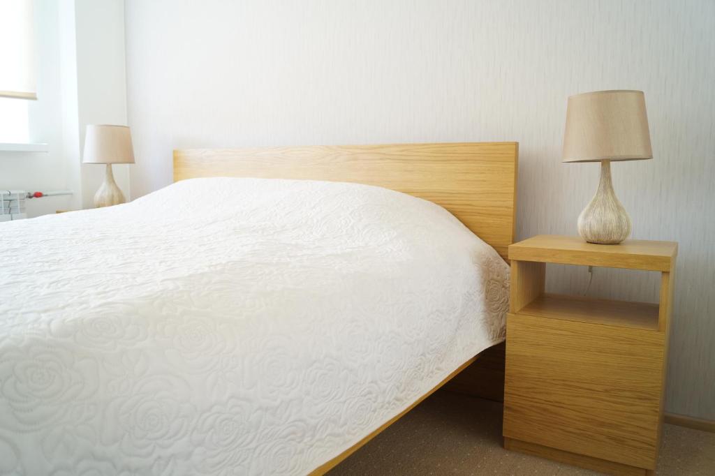 um quarto com uma cama e uma mesa de cabeceira com um candeeiro em Marja Apartment em Põltsamaa