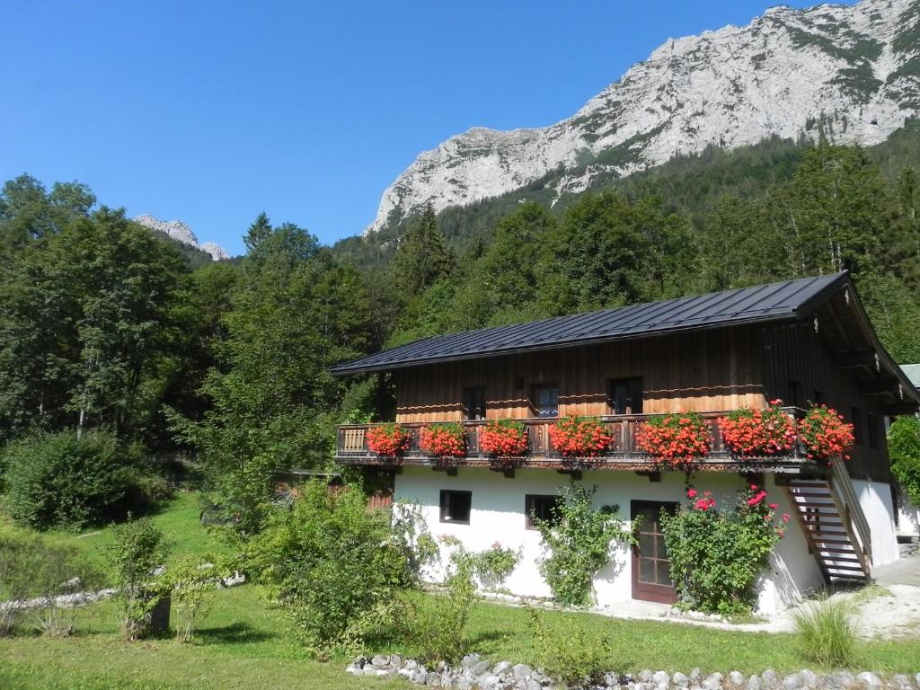 uma casa nas montanhas com flores em Haus am See em Ramsau