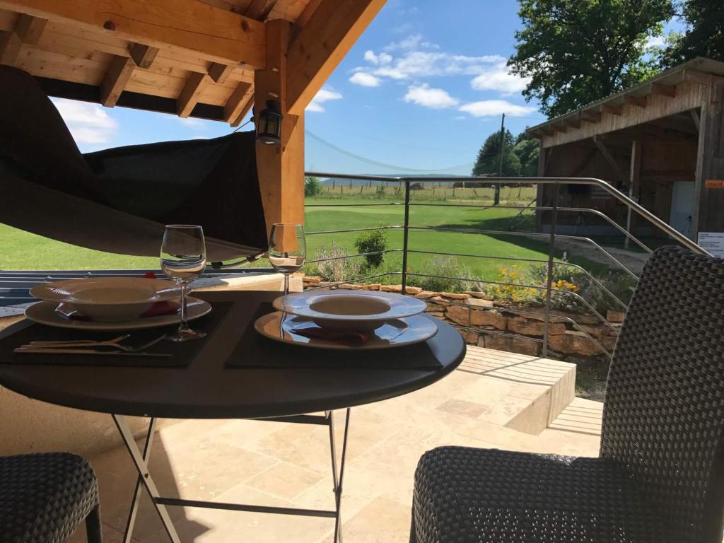 una mesa con una copa de vino en el patio en Golf de La Chassagne, en Mâlain