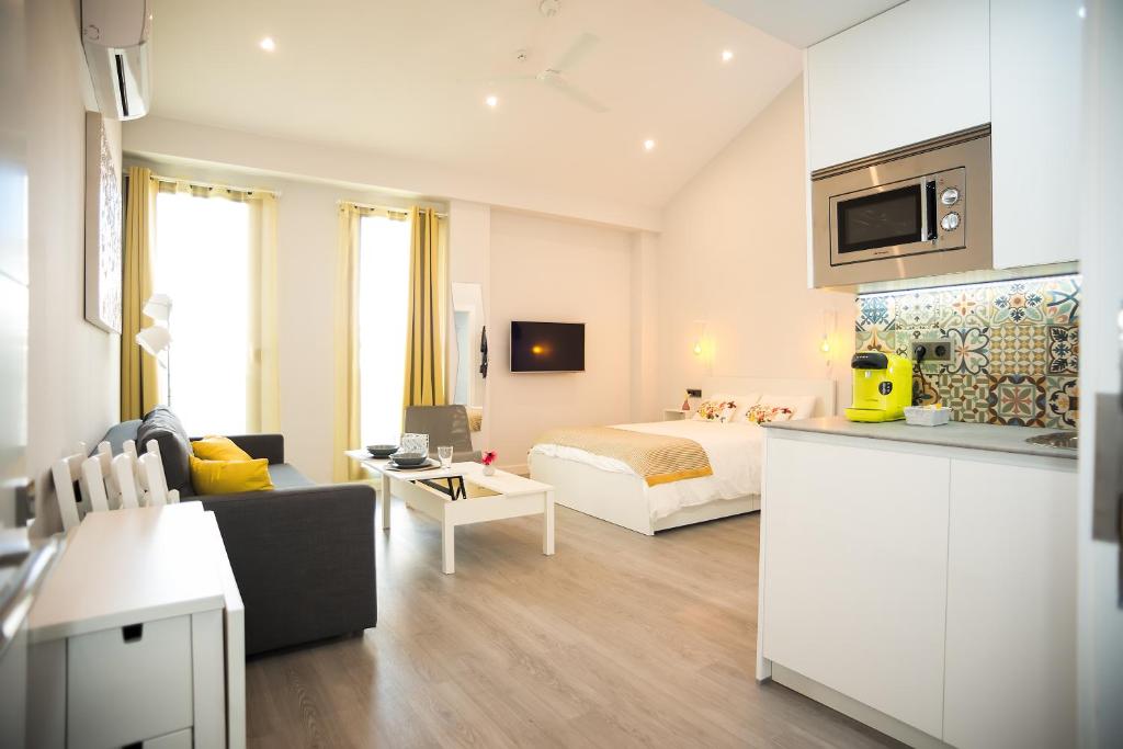 コルドバにあるAlgo Diferente Apartamentosのベッドとリビングルームが備わるホテルルームです。