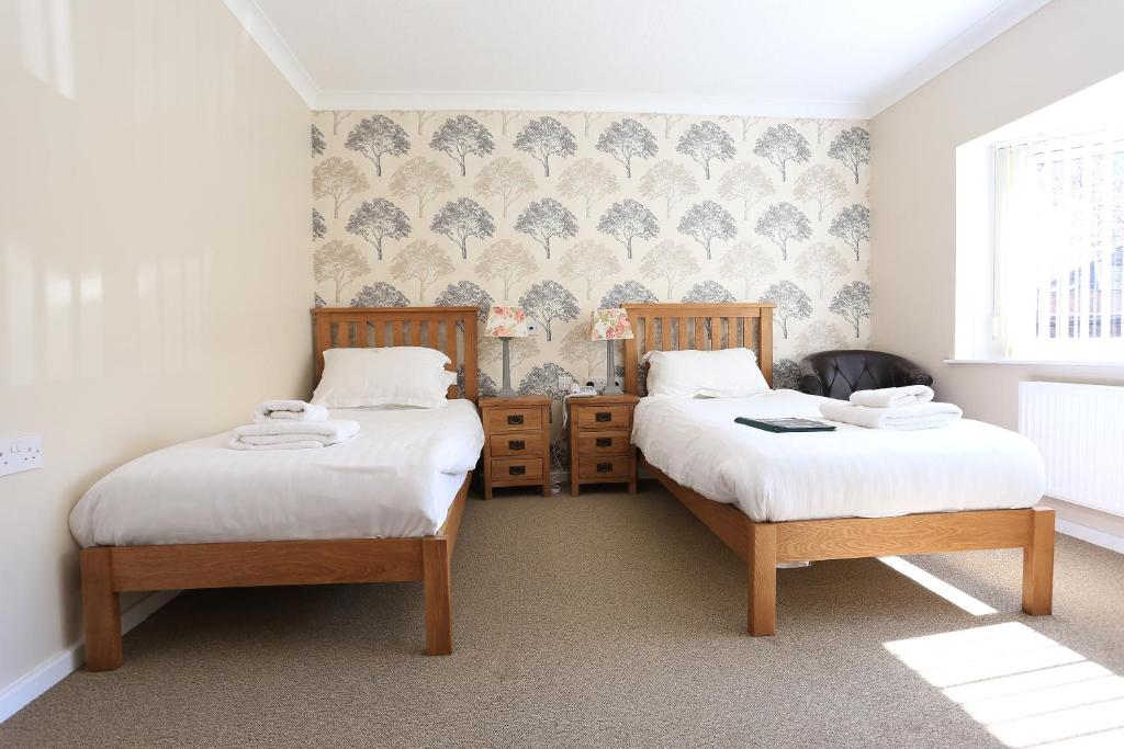 a bedroom with two beds and a wall at B+B York in York