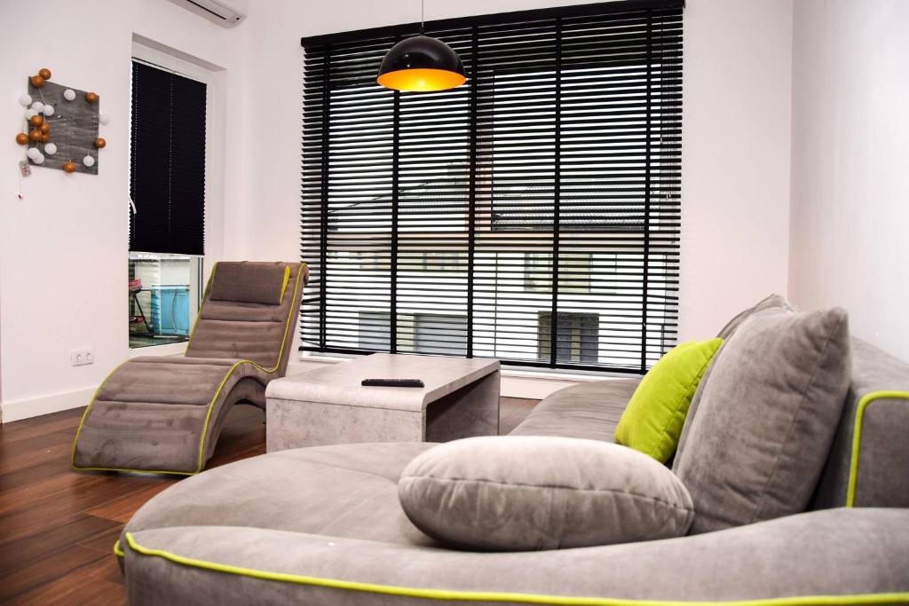 salon z kanapą, krzesłami i oknem w obiekcie Apartament Posmyka w mieście Słupsk