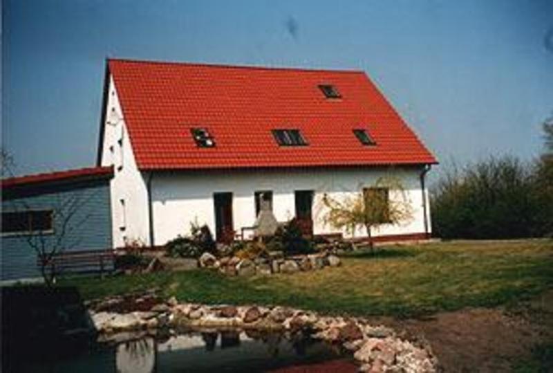 Une grande grange blanche avec un toit rouge dans l'établissement Ferienhaus Kamp Familie Diebenow, à Kamp
