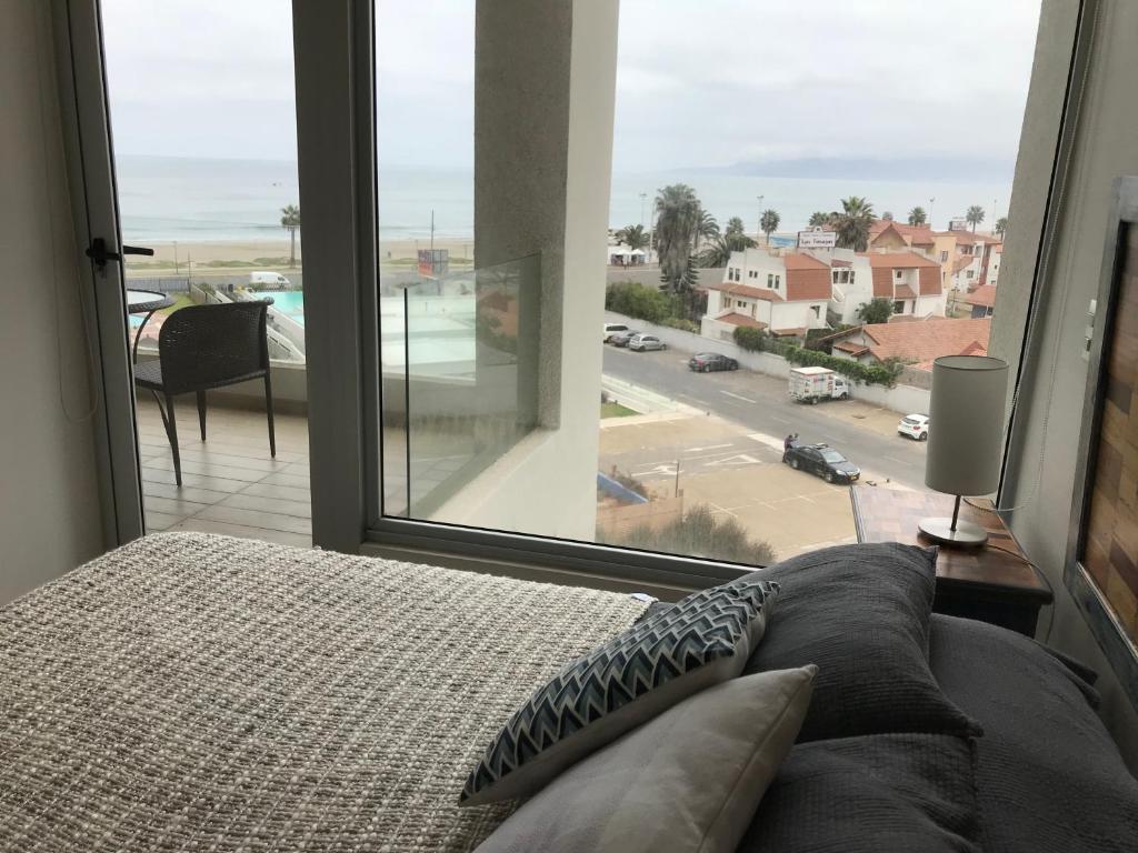 1 dormitorio con cama y ventana grande en Apartamento en Club Oceano, en Coquimbo