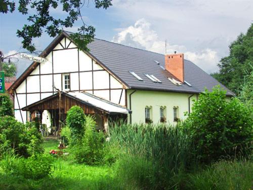 ein großes weißes Haus mit schwarzem Dach in der Unterkunft Pensjonat Kalina Komorze in Komorze