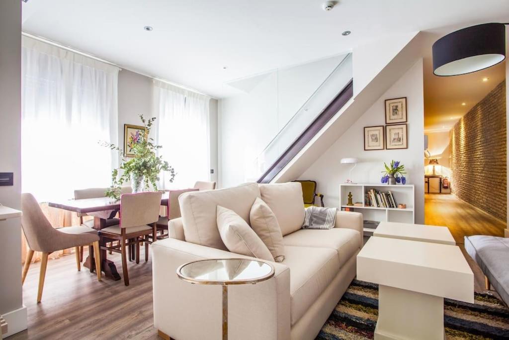 a living room filled with furniture and a large window at Apartamentos RG Dúplex San Bernardo in Seville
